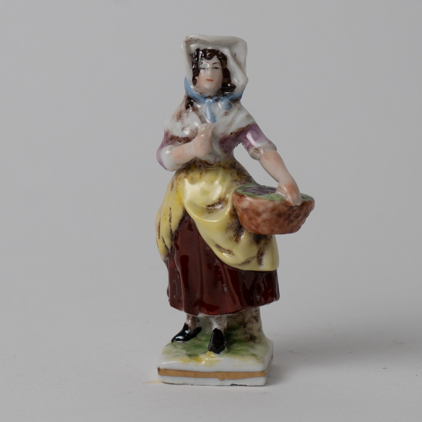 Scultura in porcellana figura femminile con cesto Capodimonte XX sec.